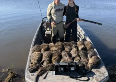 Guided Louisiana nutria hunting trip with hunters and harvested nutria loaded on an airboat in the marsh